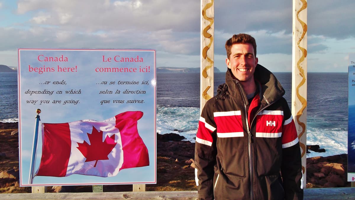 Jef van de Graaf beside the Canada begins here sign in Newfoundland