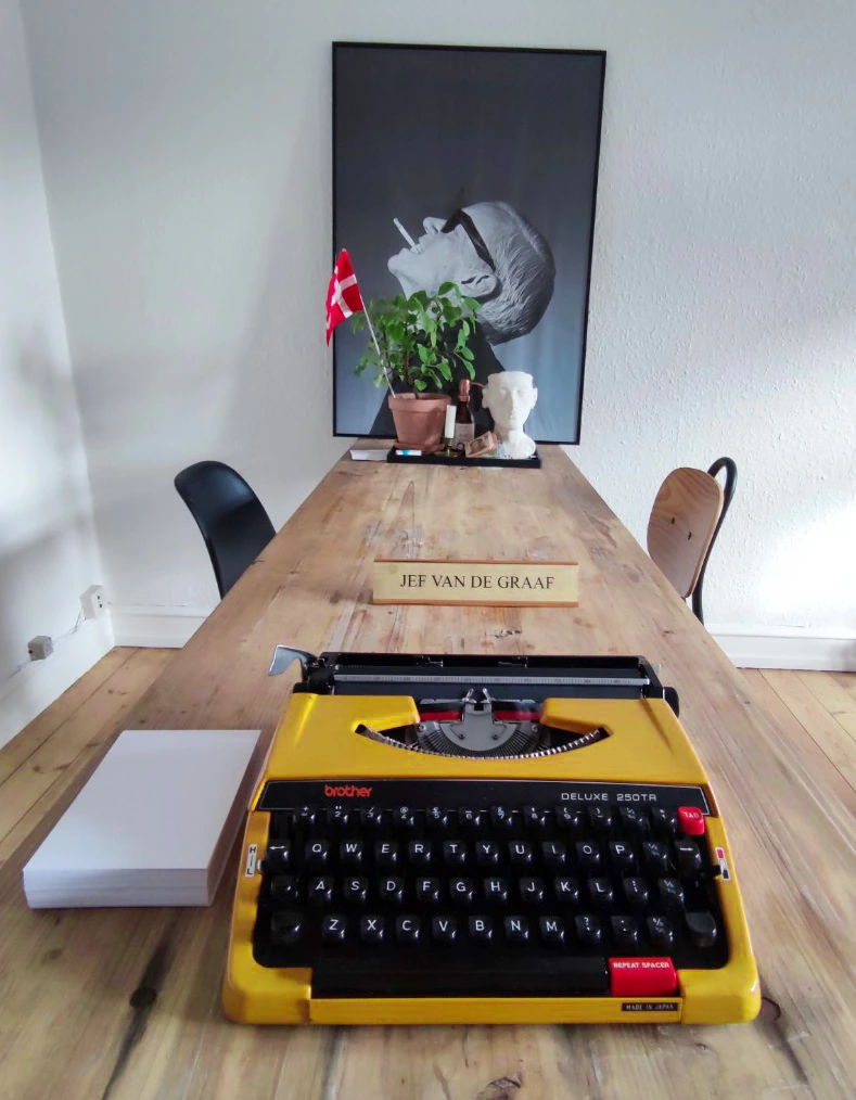 Letters from a Copywriter by Jef van de Graaf: a yellow typewriter on a long wooden desk