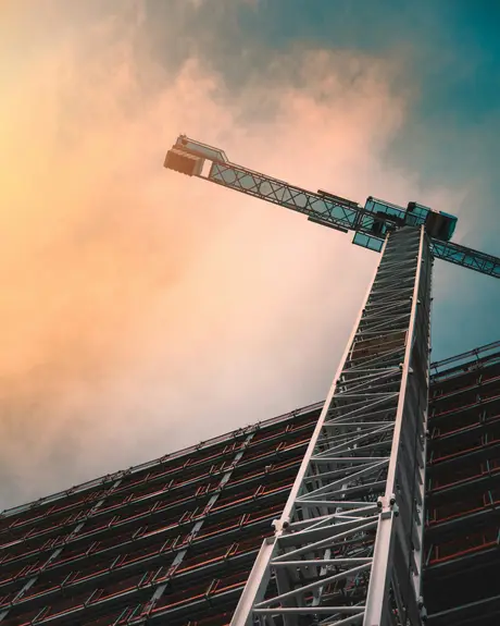 A tower crane against a sunset sky